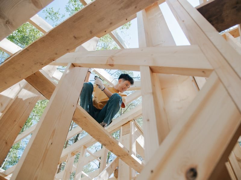 Carpenter working on a timber frame at a construction site